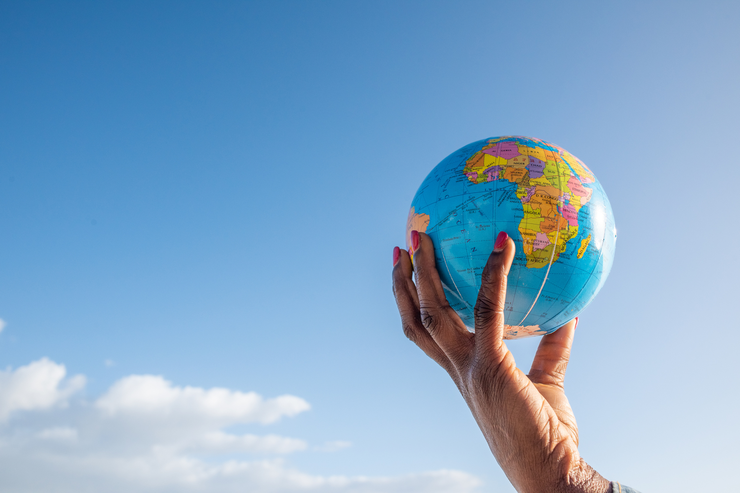 Hand Holding Globe on the Sky